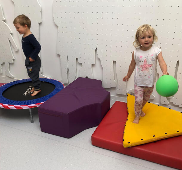 Otroci na trampolinu in blazinah.