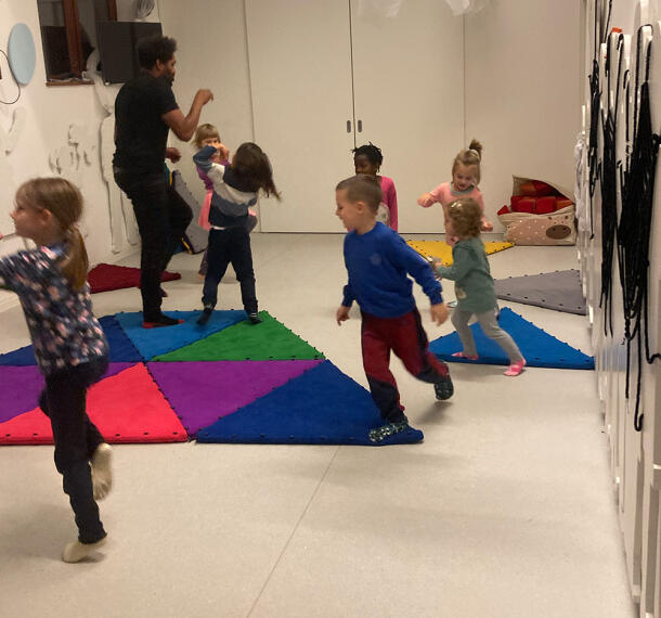 Otroci plešejo v igralnici ob spremljanju animatorja.