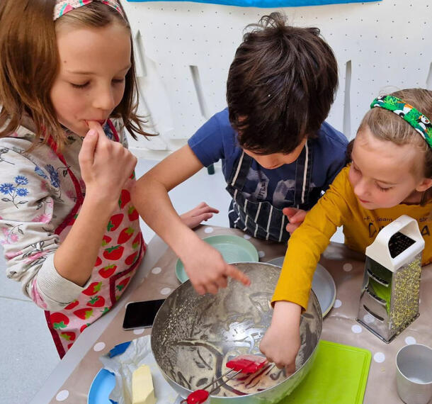 Otroci pri poskušanju sestavin za kuhanje.