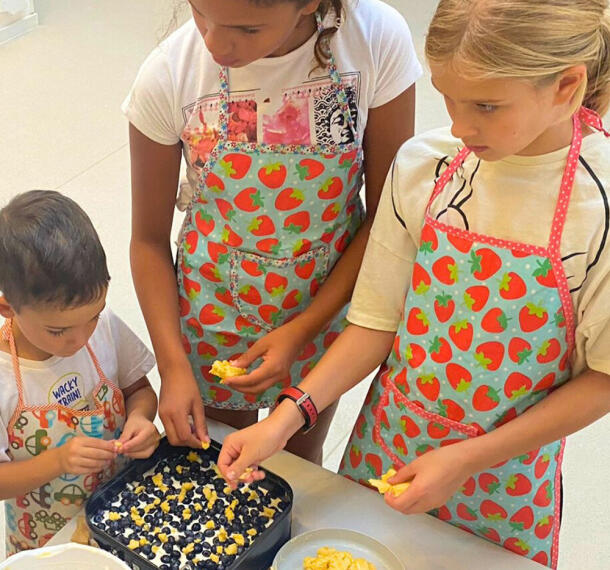 Otroci pri sestavljanju jedi v pekač.