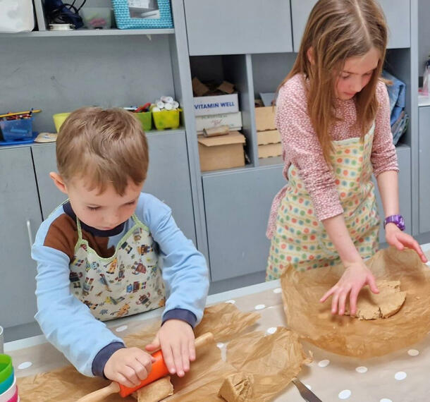 Deklica pri pripravi biskvita, deček valja.