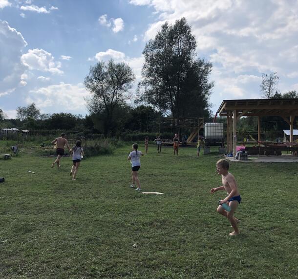 Otroci med igro na travniku.