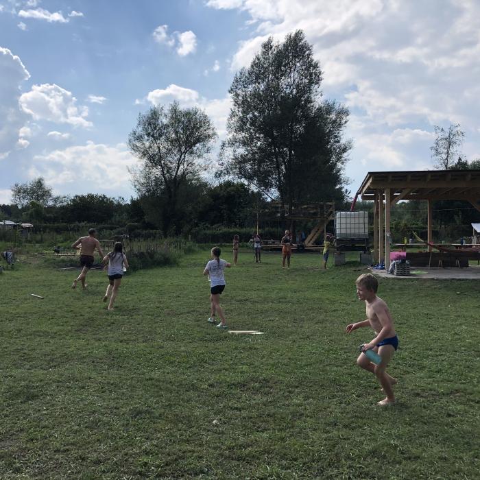 Otroci med igro na travniku.