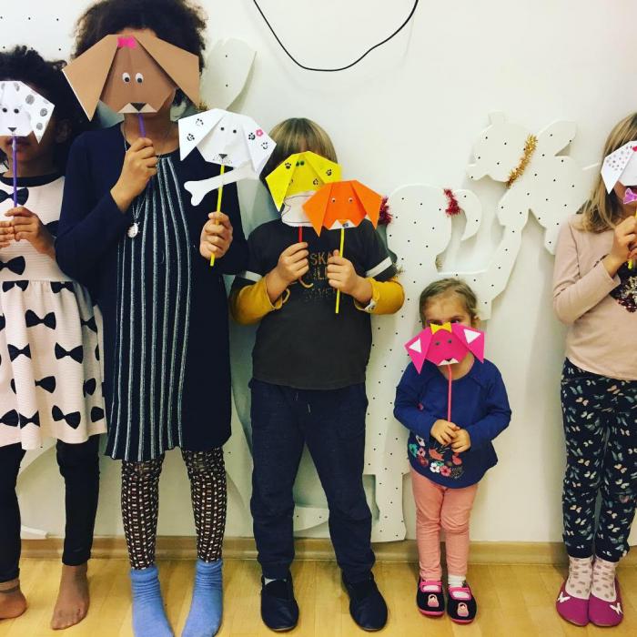 Skupina otrok z maskami, narejenimi s tehniko origami.