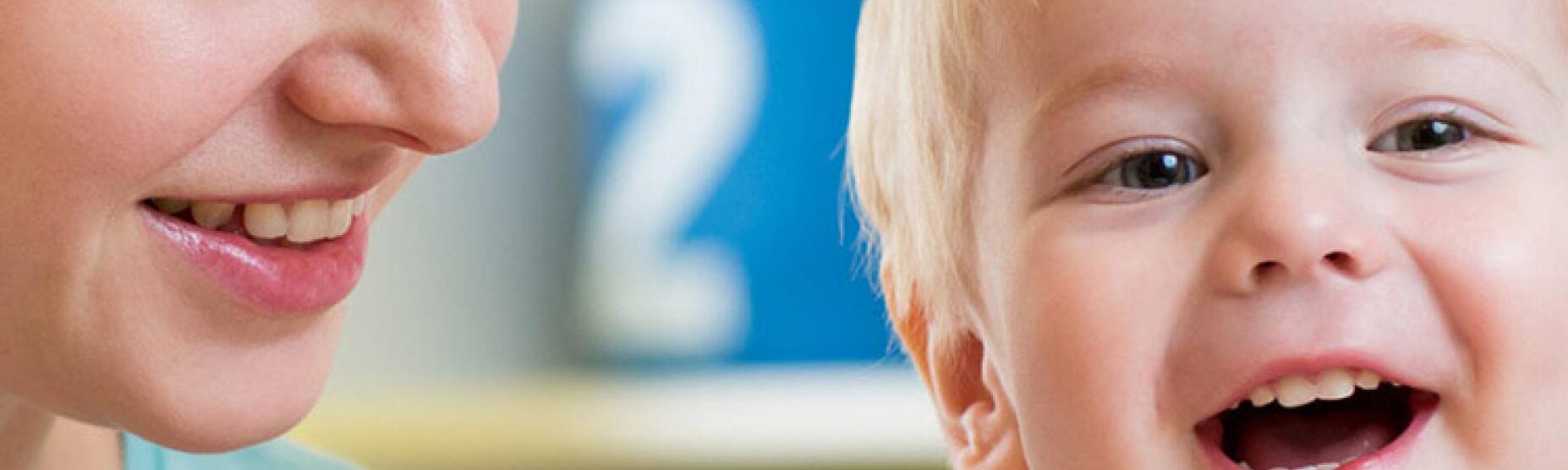 Zadovoljna mamica ob nasmejanem dojenčku.