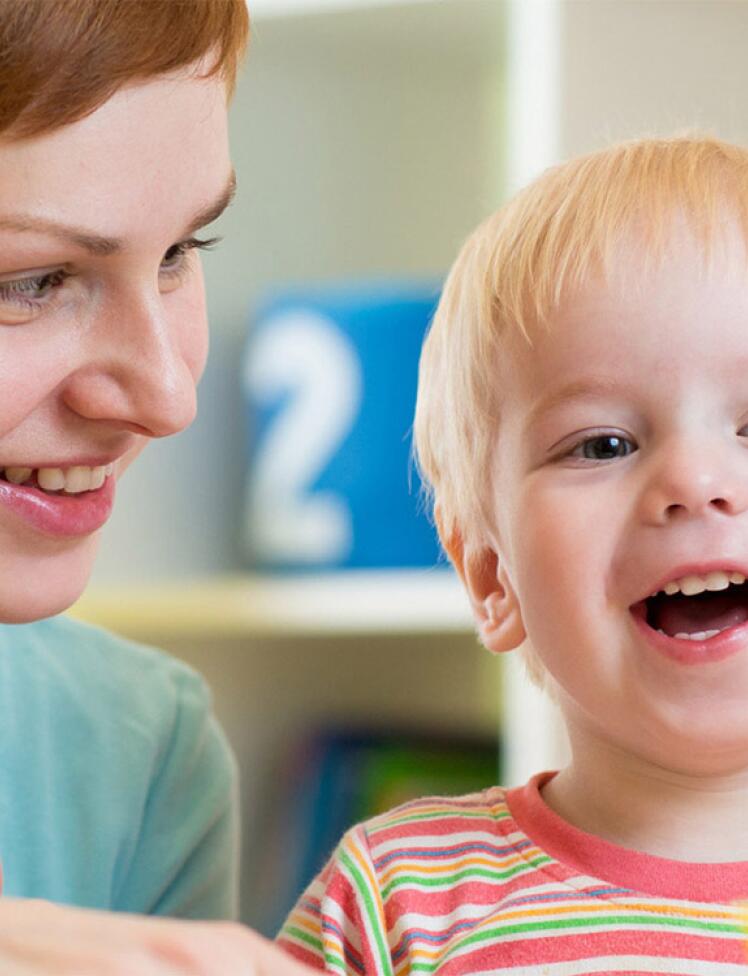 Zadovoljna mamica ob nasmejanem dojenčku.