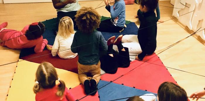 Children playing with their teacher.