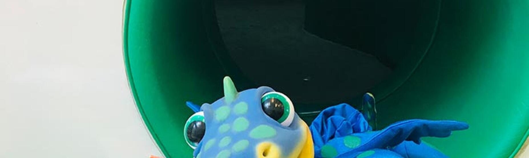 Plišasti dinozaver Dino ob branju slikanice.