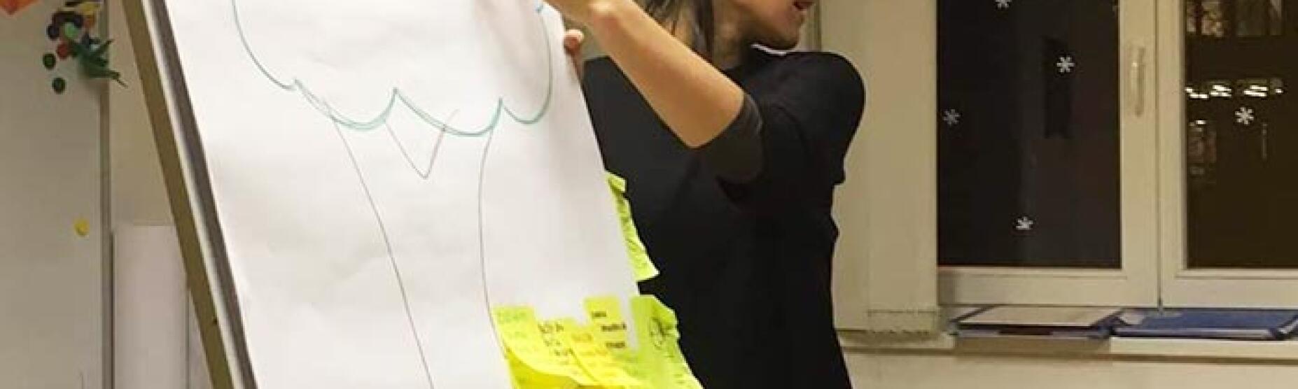 Predavateljica razlaga zapisano na tabli.