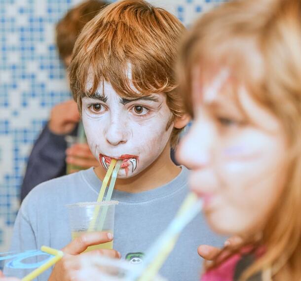 Deček na zabavi s sokom v roki.