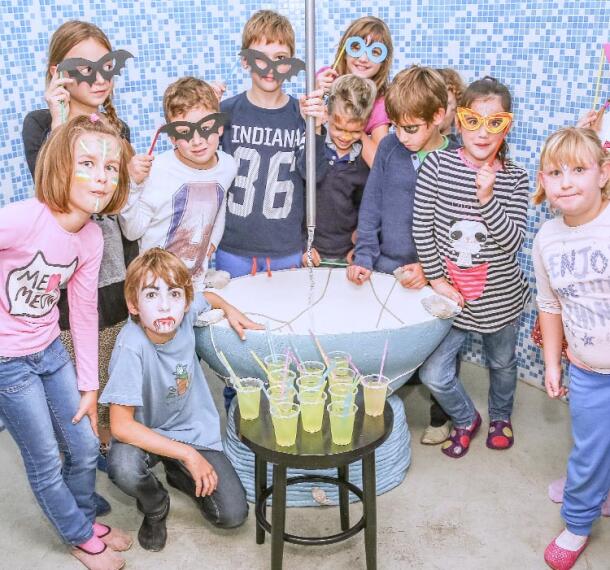 Otroci za zabavi, ki pozirajo z ročno izdelanimi papirnatimi očali.