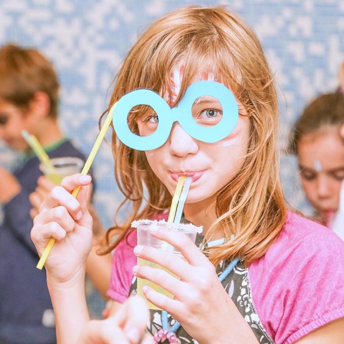 Cheerful girl at a party with juice in her hand.