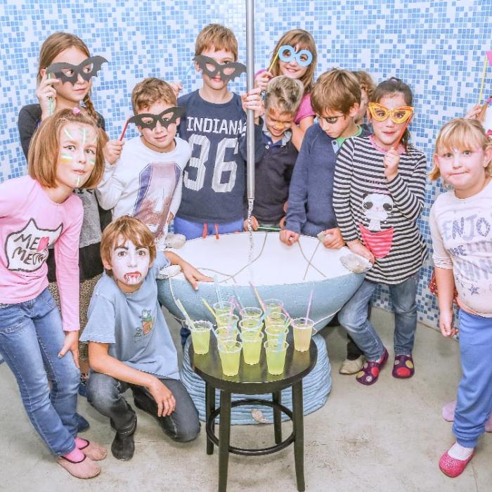 Kids at a party, posing with handmade paper glasses.