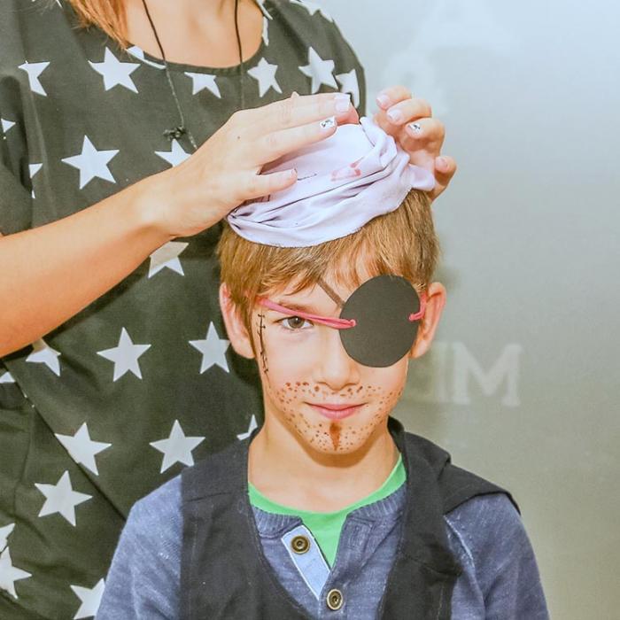 A young pirate preparing an outfit for a party.