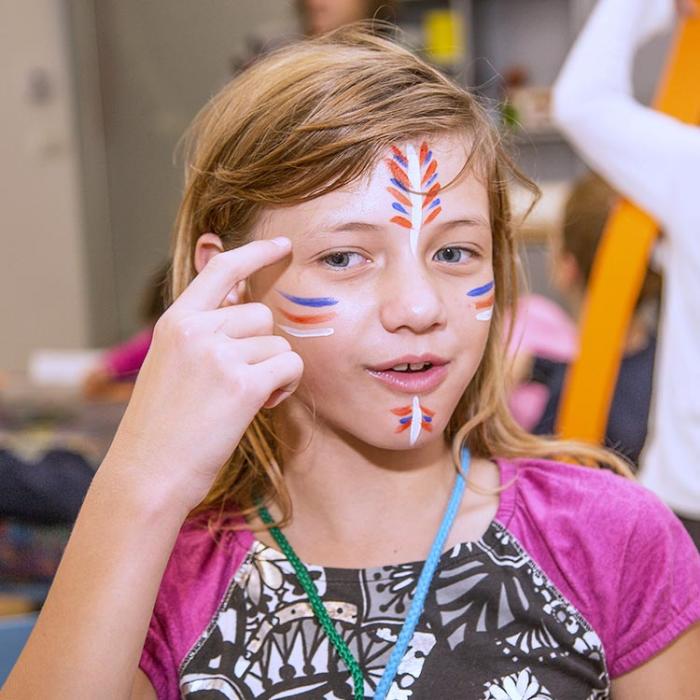 A little Indian girl with an imaginative face painting.