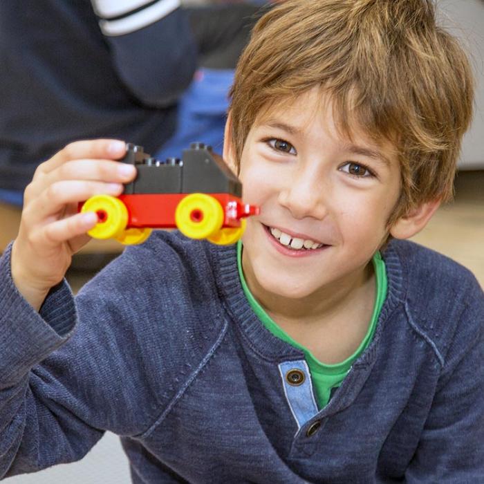A boy with a lego car.