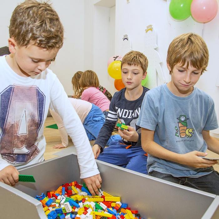 Children next to a box of Lego bricks.